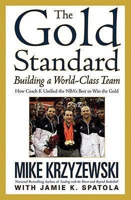 Paperback copy of "The Gold Standard: Building a World-Class Team" by Business Plus, showing the book cover with title and author.