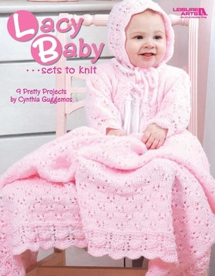Open paperback book titled "Lacy Baby Sets to Knit" by Leisure Arts, featuring colorful knitted baby clothing projects.
