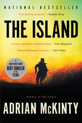 Paperback copy of "The Island" by Mulholland Books, showing the book cover with a minimalist design.