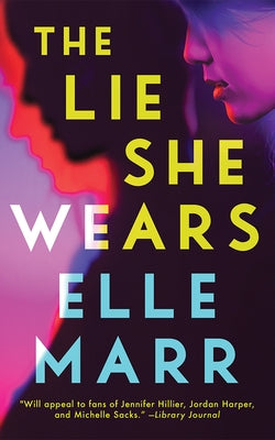 Paperback copy of "The Lie She Wears" by Thomas & Mercer featuring a cover with dark and mysterious artwork.