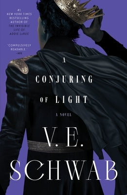 Paperback copy of "A Conjuring of Light" by Tor Books, featuring the book's cover with dark and mystical artwork.