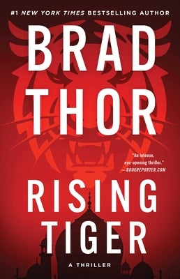 Paperback copy of Rising Tiger thriller novel by Atria Books, featuring the book cover with tiger imagery.