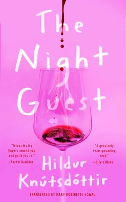 A paperback copy of "The Night Guest" by Tor Nightfire, showing the book cover with dark, moody artwork.