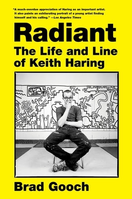 Paperback book titled "Radiant: The Life and Line of Keith Haring" featuring vibrant cover art by Harper Perennial.