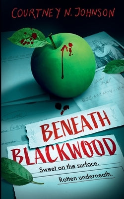 Paperback copy of Beneath Blackwood by Black Orchard Books, featuring a dark, atmospheric cover with forest imagery.