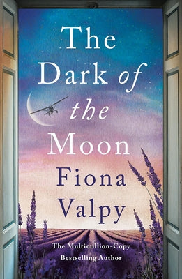 Paperback copy of "The Dark of the Moon" by Lake Union Publishing, showing the book's front cover with title and author details.