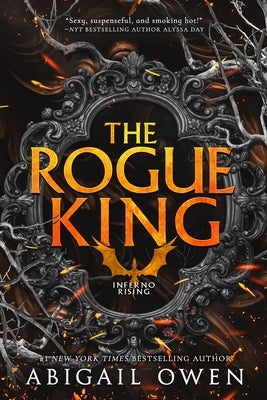 Paperback copy of The Rogue King novel by Entangled: Amara, with a dark fantasy cover featuring a mysterious king figure.